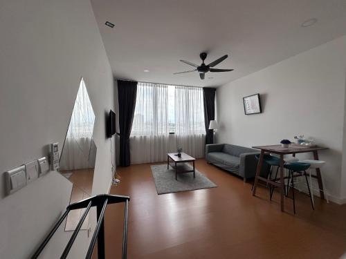 Una sala de estar con un sofá y un ventilador de techo. en Homoto Petaling Jaya, en Petaling Jaya