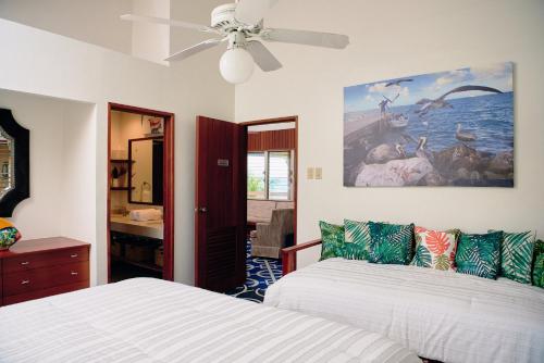 伯利茲城的住宿－Casa Al Mar, St. George's Caye - Belize，一间卧室配有两张床和吊扇