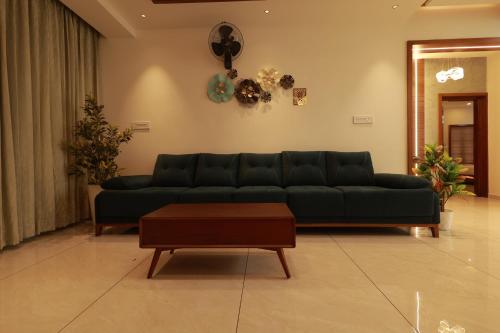 a living room with a green couch and a table at Tatvaura Resort Wayanad in Padinjarathara