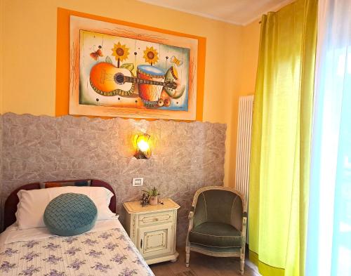 1 dormitorio con 1 cama, 1 silla y 1 foto en Florivana Boutique Hotel Ristorante, en San Pietro in Cariano
