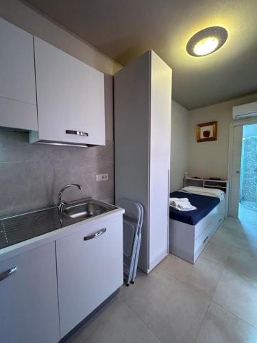 eine Küche mit einem Waschbecken und einem Sofa in einem Zimmer in der Unterkunft B&B DaBi in Alghero