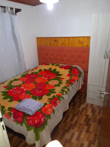 1 dormitorio con 1 cama con manta de flores en Departamento franco 2 en Los Antiguos
