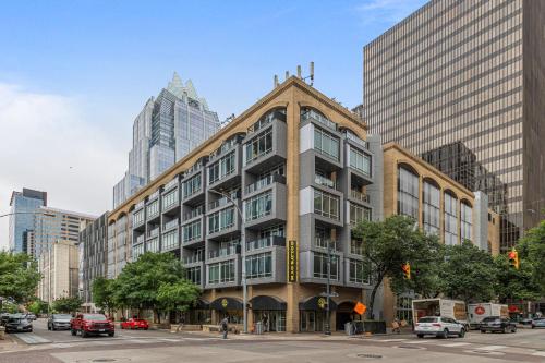 a building on a city street with tall buildings at Littlefield Lofts, Hosted by Placemakr - 6th St in Austin
