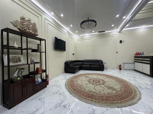 sala de estar con sofá y alfombra en Hello Dushanbe Hostel en Dusambé