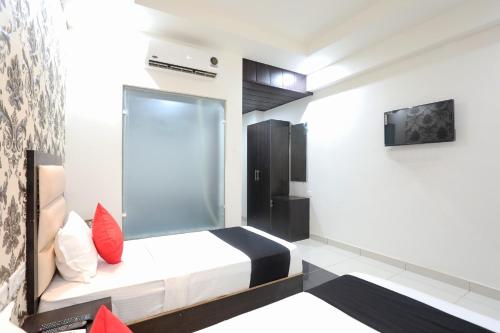 a bedroom with a bed and a tv on a wall at OYO Hotel Aroma Regency in Meerut