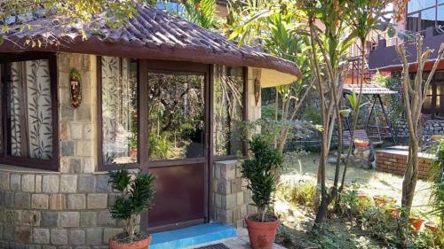 a small house with a door and some trees at Oxygen Homestay-A Blissful Retreat in Dehradun