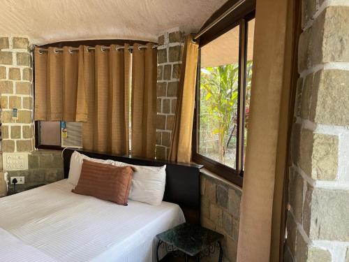 ein kleines Bett in einem Zimmer mit Fenster in der Unterkunft Oxygen Homestay in Dehradun