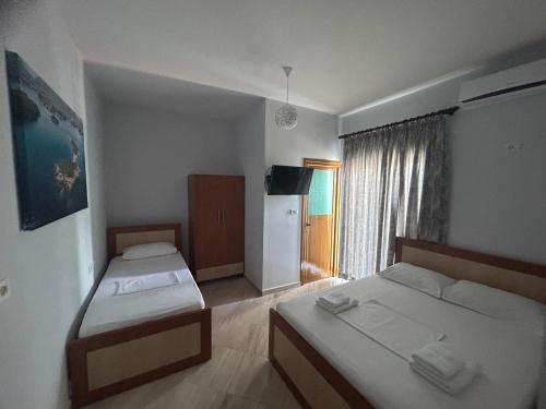 a hotel room with two beds and a window at Vila Jeti in Ksamil