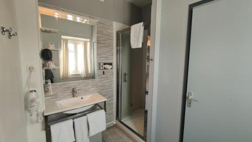 a bathroom with a sink and a shower at Hôtel Saint Jean in Tours