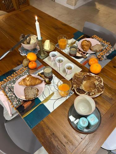 Una mesa con platos de comida y una vela. en Maison Bossanne, en Barbières