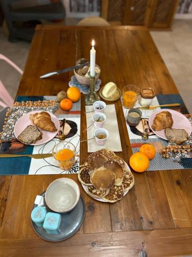 Una mesa con platos de comida y una vela sobre ella. en Maison Bossanne, en Barbières