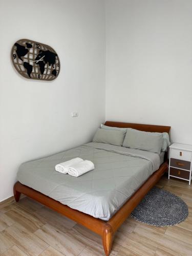 a bed with a wooden frame and a clock on the wall at Rooms Getafe in Getafe