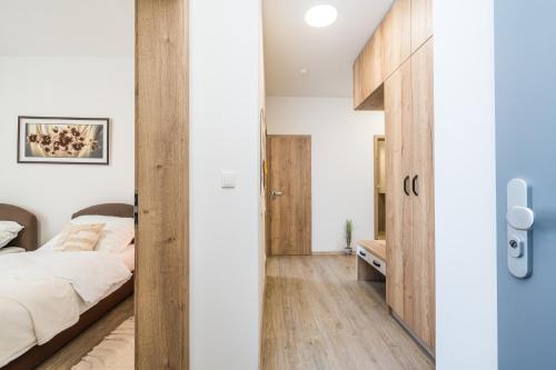 フラデツ・クラーロヴェーにあるPerla Hradceの白い壁とベッドが備わるウッドフロアのベッドルーム1室が備わります。