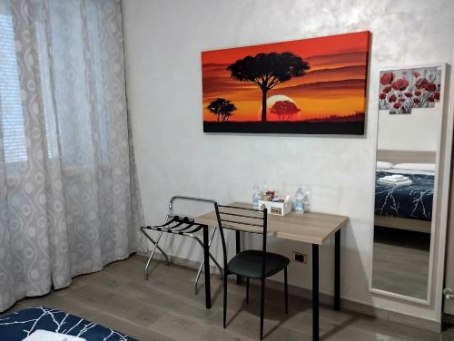 a room with a desk with a chair and a painting at Roma Tourist Lease in Acilia