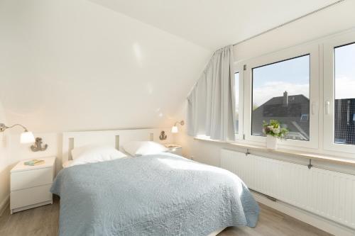 um quarto branco com uma cama e uma janela em Badeweg 4 Haus Bullerbü, App 10 em Scharbeutz