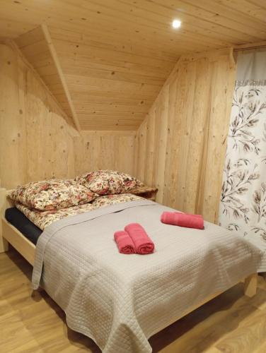 a bedroom with a bed with two red slippers on it at Domek na Bachledowce 2 in Leszczyny