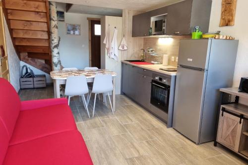 a kitchen with a red couch and a table with chairs at Estatico 1 - T2 duplex apartment sleeps 4 in Névache