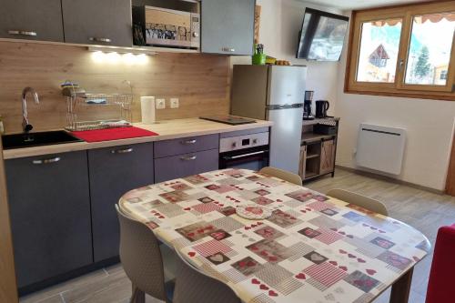 a kitchen with a table and a counter top at Estatico 1 - T2 duplex apartment sleeps 4 in Névache
