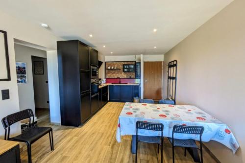 une cuisine avec une table et des chaises dans une pièce dans l'établissement La feclaz - Magnifique appartement 6 personnes, à La Féclaz