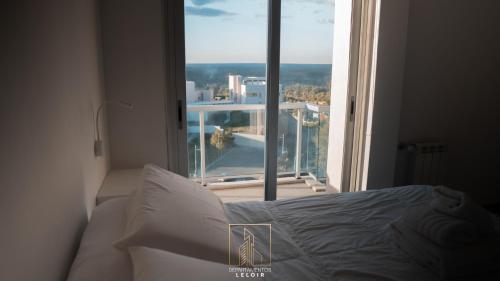 a bedroom with a bed in front of a window at Departamentos Leloir in Neuquén