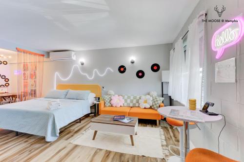 a bedroom with a bed and a couch and a table at The Moose #10 - Stylish Loft with King Bed, Free Parking & Wi-Fi in Memphis
