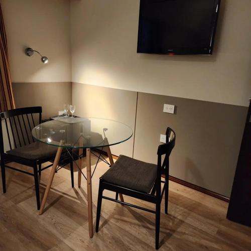 a dining room with a glass table and two chairs at Hotel Riogrande in Santa Fe