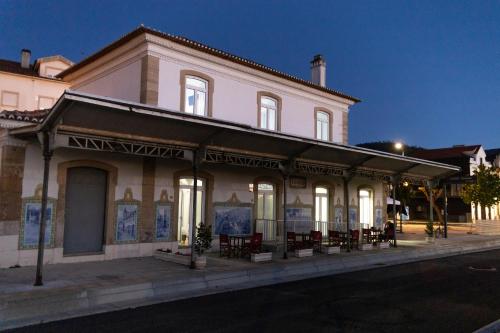 a building on the side of a street at night at Lousã Estação AL in Lousã