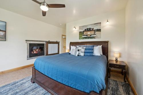 um quarto com uma cama azul e uma lareira em Summer Honey em Kalispell