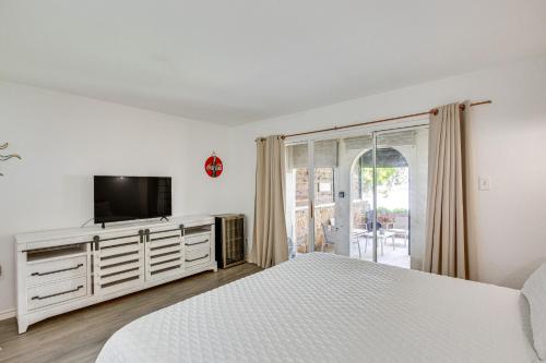 a white bedroom with a bed and a television at 7 Mi to Winery Lakefront Rockwall Home with Deck in Rockwall