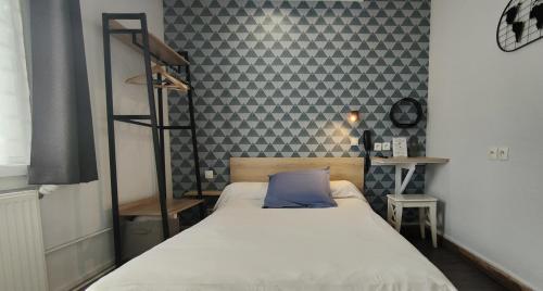 a bedroom with a bed with a blue pillow on it at Hôtel Saint Jean in Tours