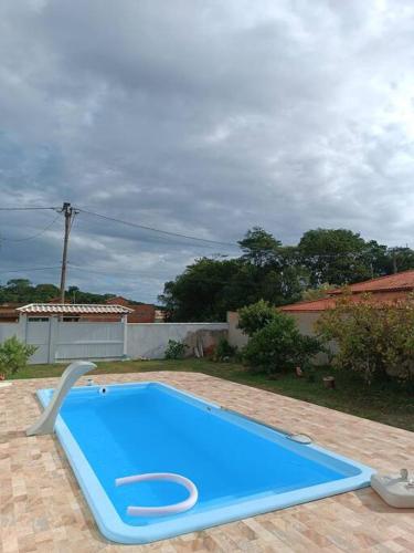 a large blue swimming pool in a yard at Casa em Unamar com piscina privativa in Cabo Frio