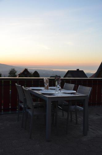 einen Tisch und Stühle auf einem Balkon mit Blick auf den Sonnenuntergang in der Unterkunft Gasthof Kreuz in Bildstein