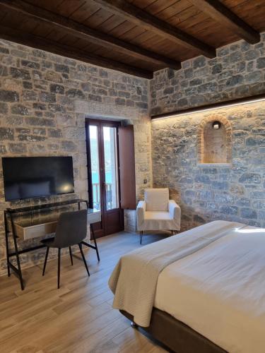 a bedroom with a bed and a desk and a tv at Manifest Boutique Hotel in Oítilon