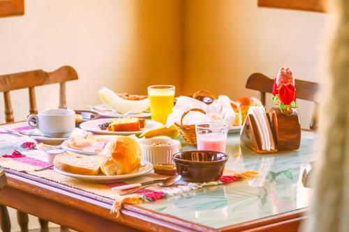 una mesa con comida para el desayuno y bebidas en ella en VELINN Pousada Highland, en Santo Antônio do Pinhal