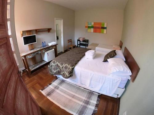 ein Schlafzimmer mit einem großen Bett und ein Wohnzimmer in der Unterkunft Pousada Mangas in Manguinhos