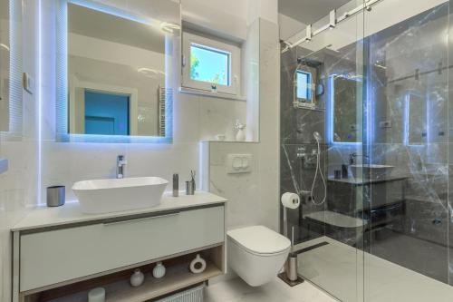 Un baño con lavabo, inodoro y ducha. en Villa A&D, en Slatine