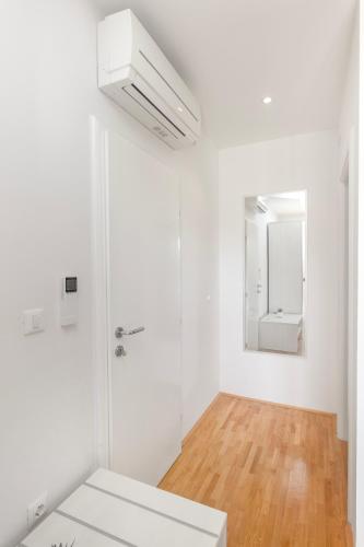 a white bathroom with a sink and a mirror at Beachfront Vila Angelina in Vinišće