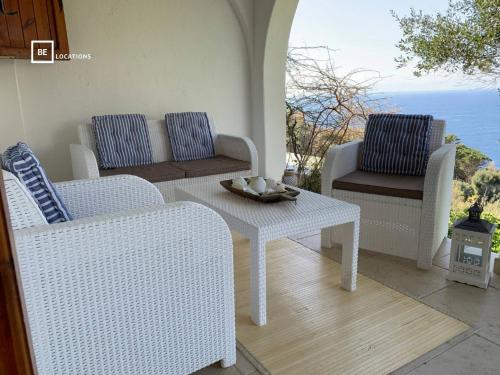d'une terrasse avec 2 chaises en osier et une table. dans l'établissement BellaVista Ivonne - Belocations, à Torre delle Stelle