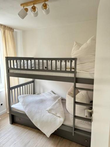 a bunk bed with white pillows on top of it at 2,5 Zimmer Ferienwohnung Fehmarn mit eigenem Parkplatz in Fehmarn
