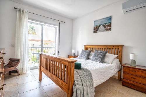 - une chambre avec un lit et une grande fenêtre dans l'établissement Oasis park 2 bedroom top floor Apartment AT72, à Portimão
