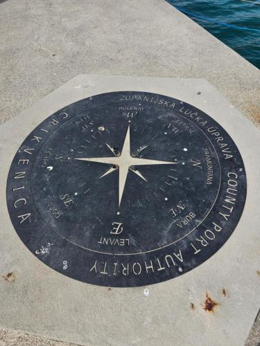 a clock on the ground in front of the water at 250 mobile home Selce in Selce