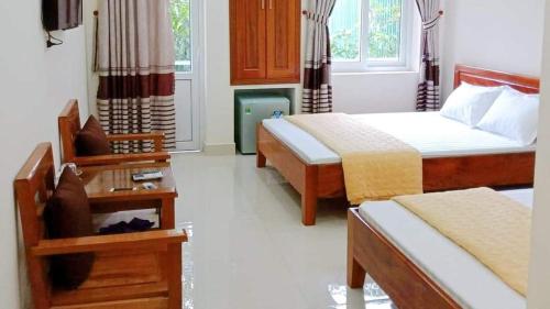 Habitación de hotel con 2 camas y mesa en Khách Sạn Thành Đạt, en Thương Xà (2)