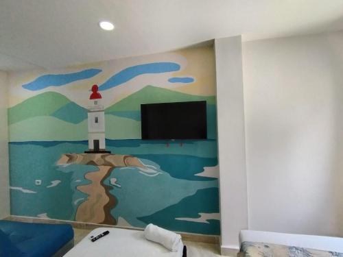 a room with a wall with a painting of a lighthouse at Avadia del Mar in Cartagena de Indias