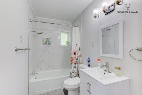 a white bathroom with a toilet and a sink at The Moose #11 - Luxe Modern loft with King Bed, Free Parking & Wi-Fi in Memphis