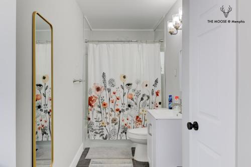 a bathroom with a toilet and a shower curtain at The Moose #11 - Luxe Modern loft with King Bed, Free Parking & Wi-Fi in Memphis