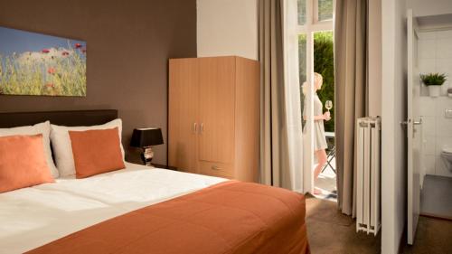 a bedroom with a bed and a woman walking out the door at Appartementen Valkenburg in Valkenburg