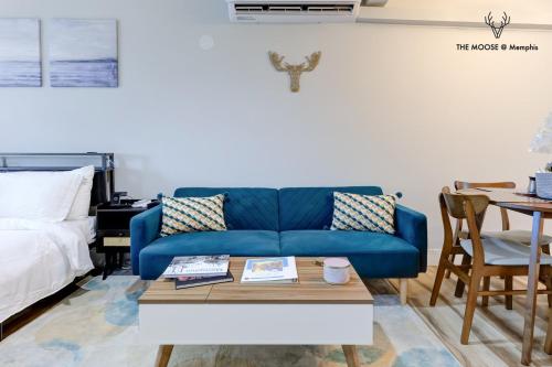 a living room with a blue couch and a table at The Moose #11 - Luxe Modern loft with King Bed, Free Parking & Wi-Fi in Memphis