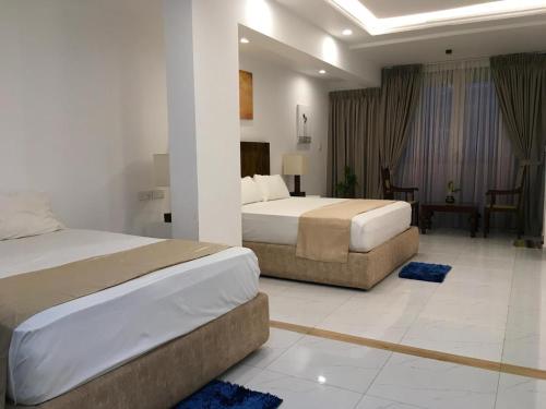 a bedroom with two beds and a living room at Lavinia Bay Beach Hotel in Mount Lavinia
