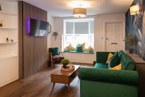a living room with a green couch and a window at Royal Retreat & Lego Lodge in London