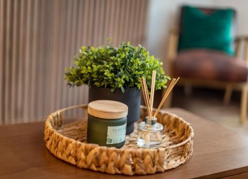 a tray with a candle and a plant on a table at Royal Retreat & Lego Lodge with free parking in Windsor
